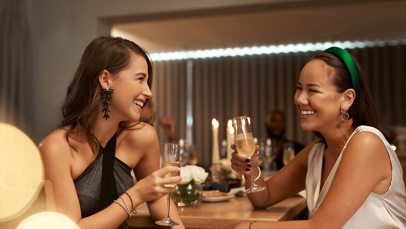 Two women laughing with drinks